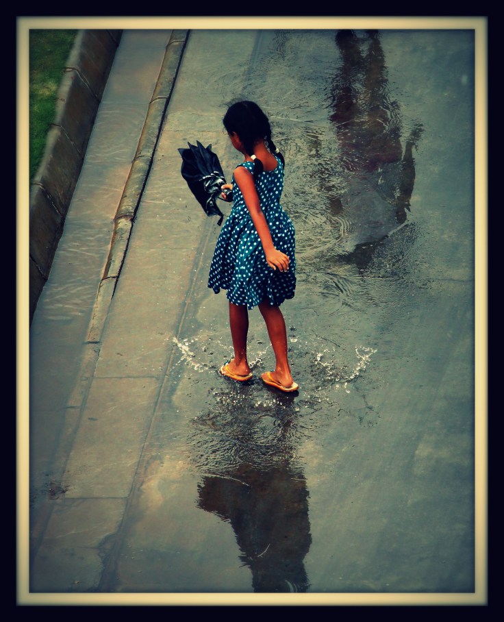 A girl and her shadow in the rain water.